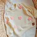 Sweterek dla dziewczynki kremowy z kwiatami róż